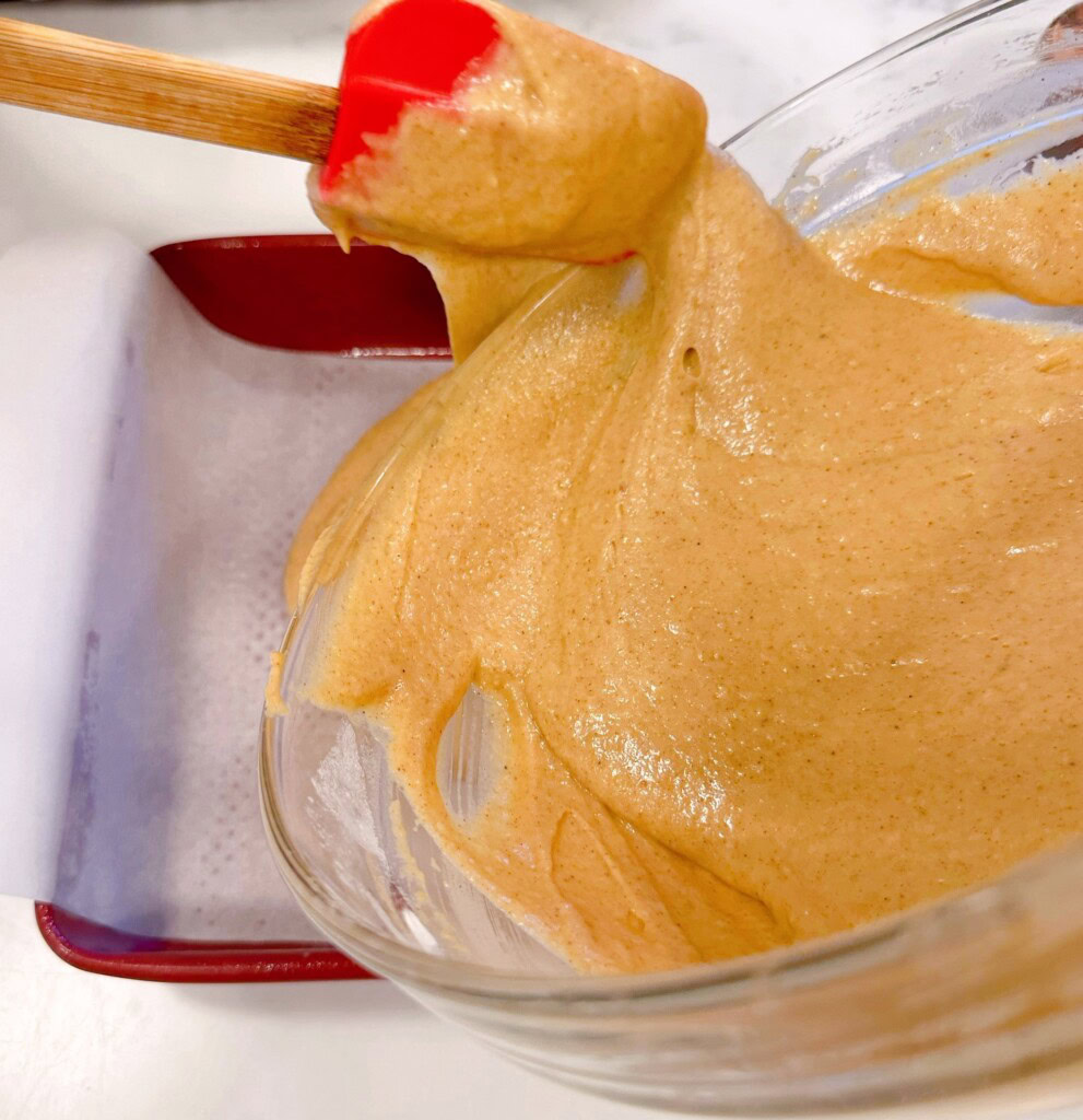 Adding the cake batter to the prepared cake pan.