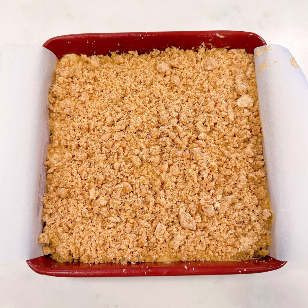 Adding crumb on top of the cake batter and getting it ready to bake.