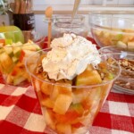 Caramel Apple in a cup with toppings.