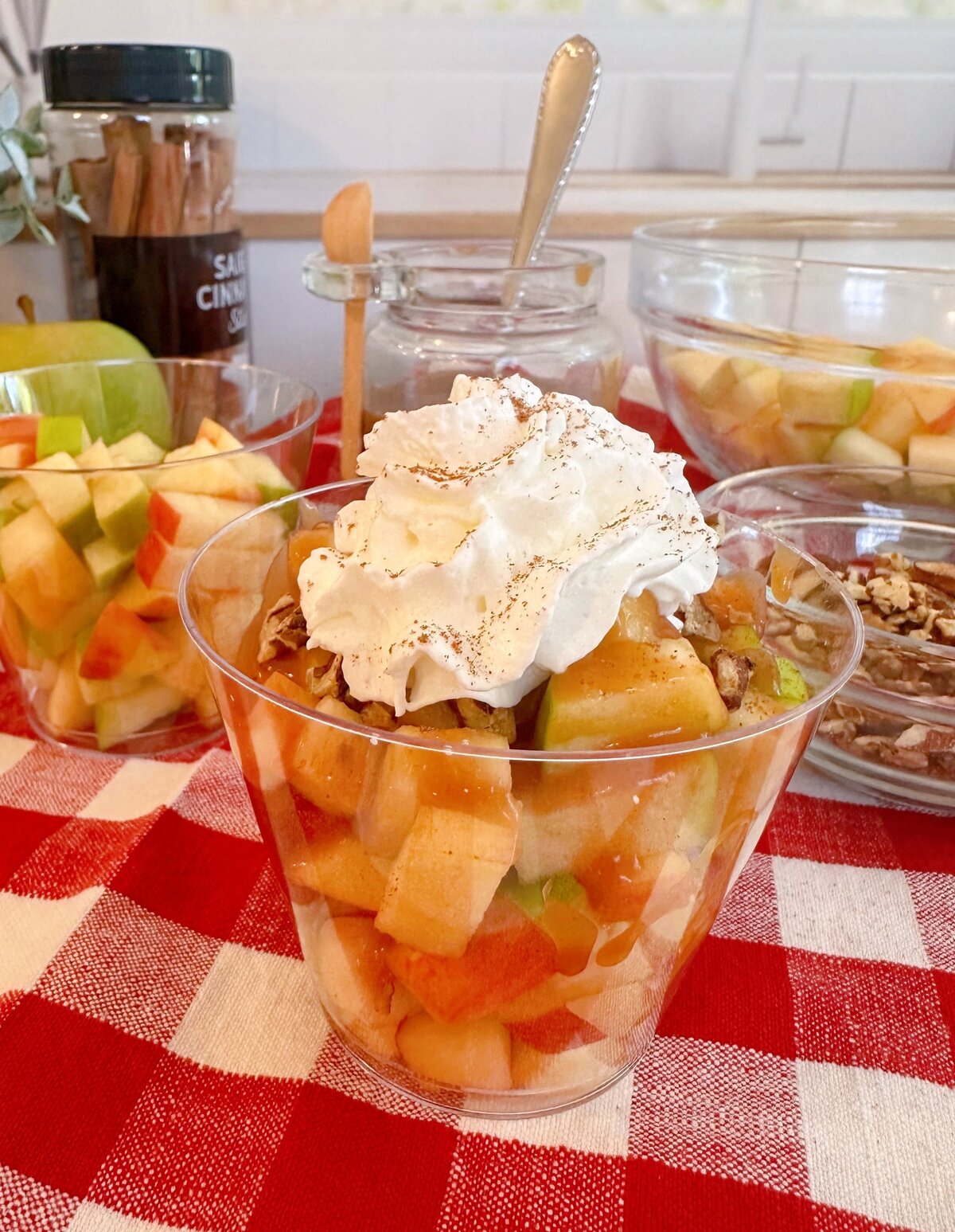 Caramel Apple in a cup with toppings.
