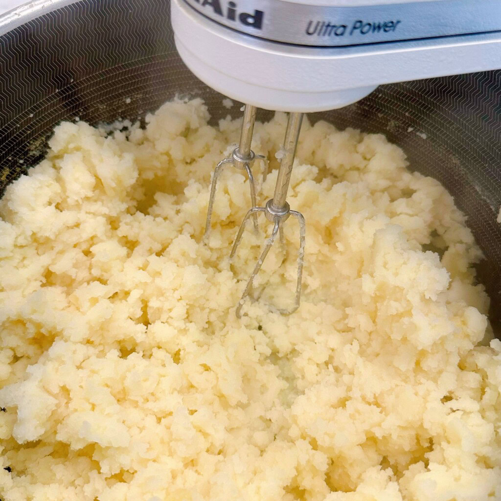Mixing potatoes with electric mixer.