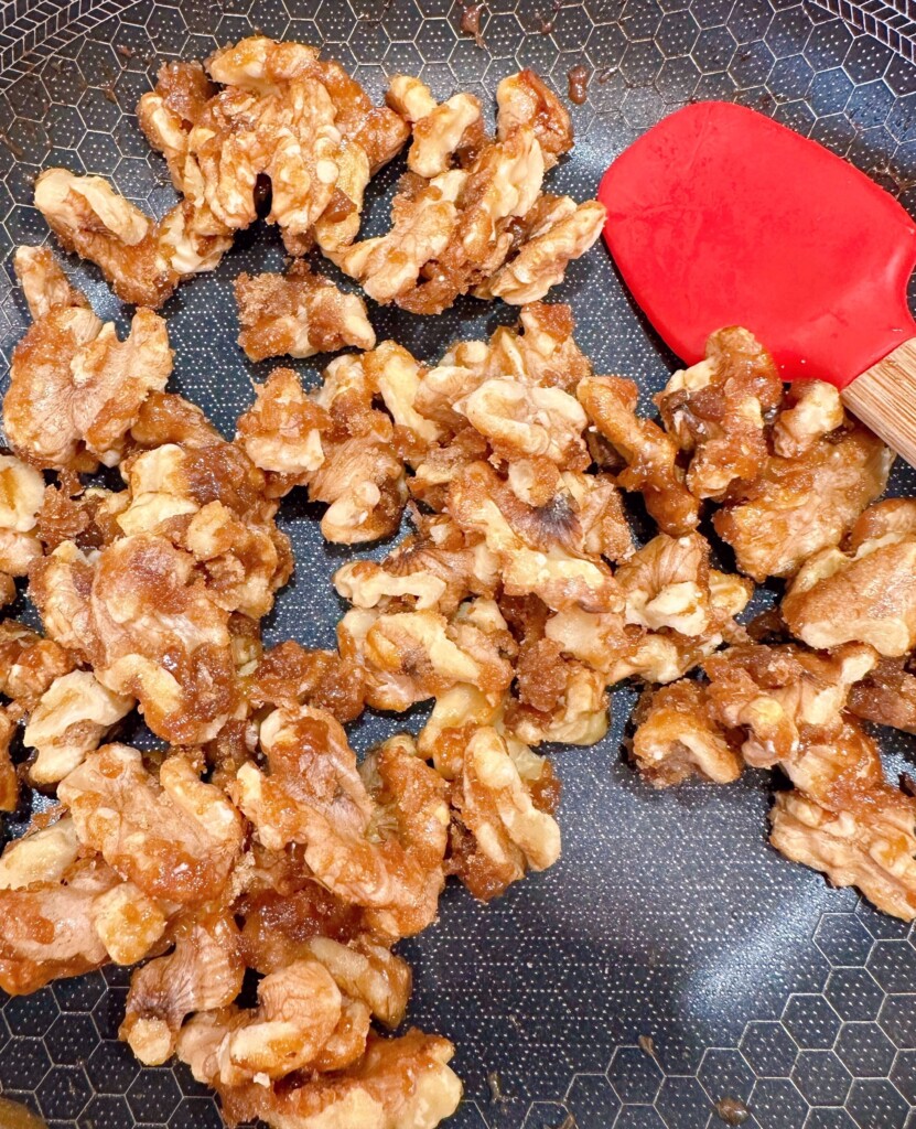 Nuts in small skillet coated with brown sugar.
