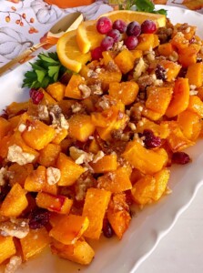 Roasted butternut squash with cranberries on a serving plate.