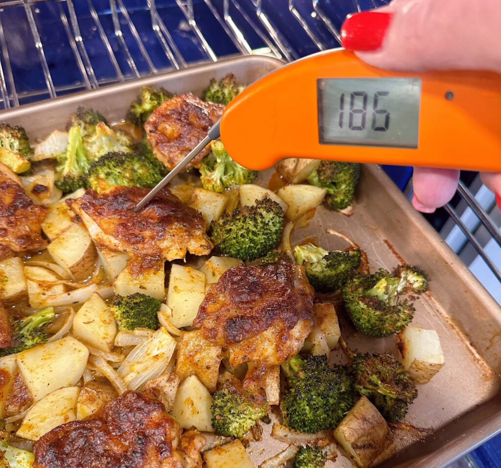 Checking the internal temperature of the chicken with a thermometer.