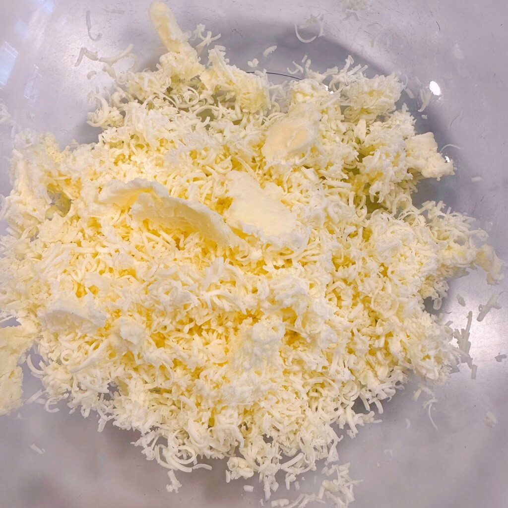 Grated butter in a large glass bowl.