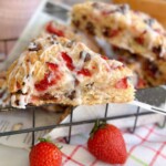 Strawberry Chocolate Chip Scones in a basket with fresh strawberries surrounding it.