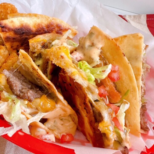 Bacon Cheese Burger Smash Quesadilla's cut into quarters and set in a red basket.