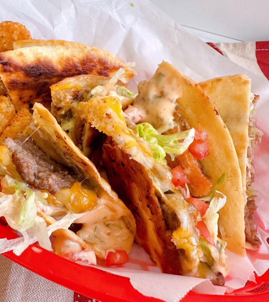 Bacon Cheese Burger Smash Quesadilla's cut into quarters and set in a red basket.