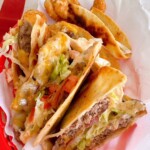 Grilled Smash Burger Quesadillas stacked in a red plastic food basket.