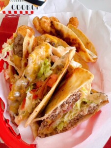 Grilled Smash Burger Quesadillas stacked in a red plastic food basket.