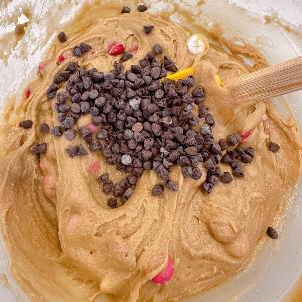 Adding M&M's and chocolate chips to blondie batter. 