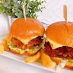Fish sandwiches on a white platter with french fries.