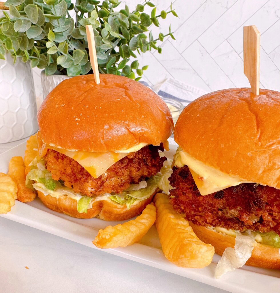 Fish sandwiches on a white platter with french fries.