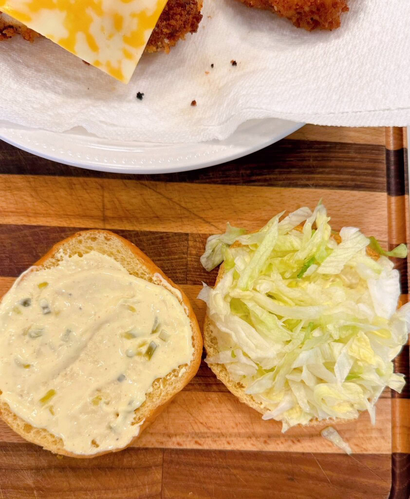 Adding Lettuce to sandwiches.