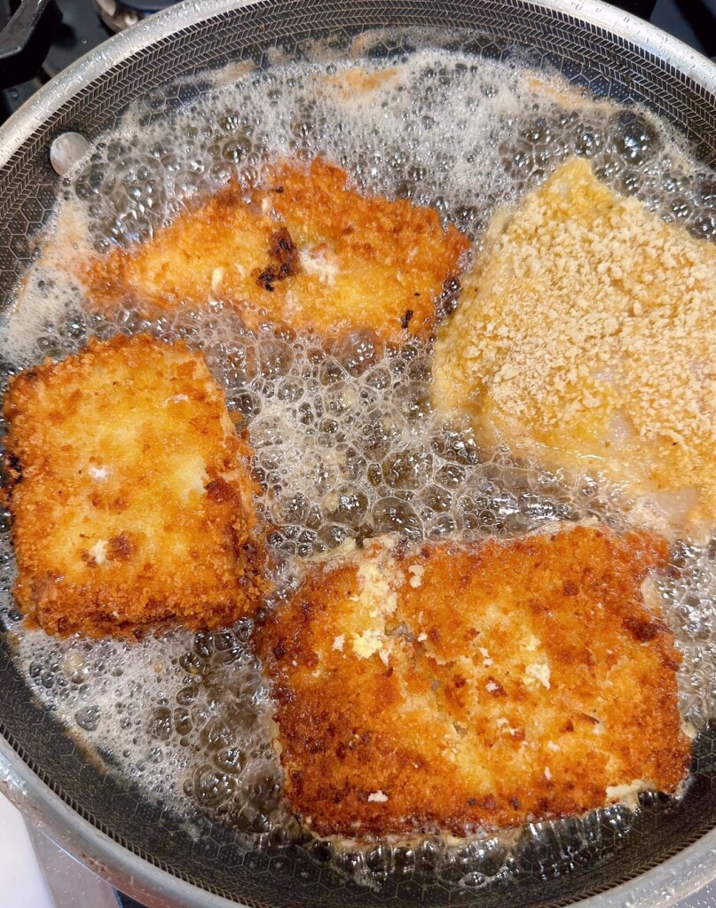 Frying fish filets in a large skillet.