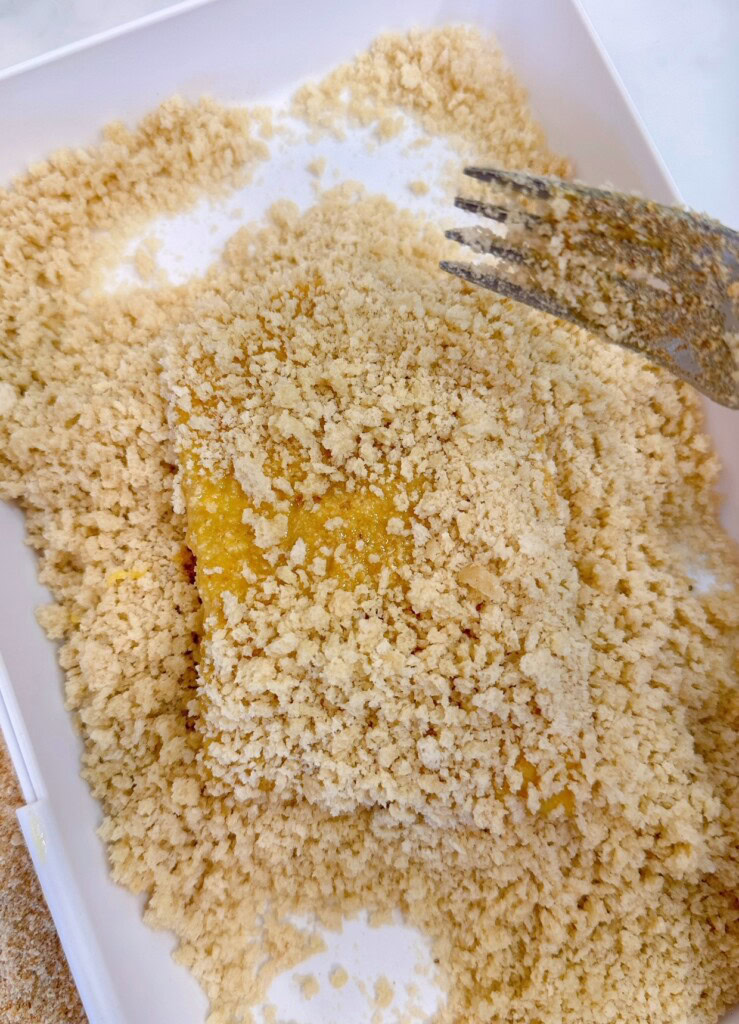 Dipping double coated fish in the panko bread crumbs.