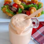 Easy Serect Sauce recipe in a glass jar and dripping slightly down the sides.