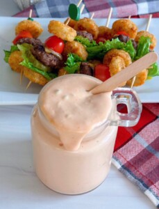 Easy Serect Sauce recipe in a glass jar and dripping slightly down the sides.