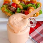 Overhead shot of secret sauce in a jar with a wooden serving spoon.