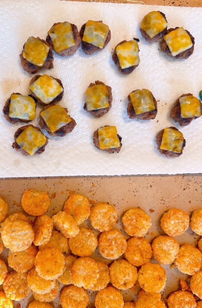 Baking sheet with one half of the pan lined with paper towels for mini hamburger patties and crispy crowns.
