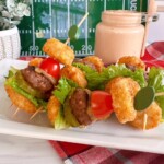 Tater Tot Mini Cheeseburger Bites on a white platter with secret sauce in a jar in the background.