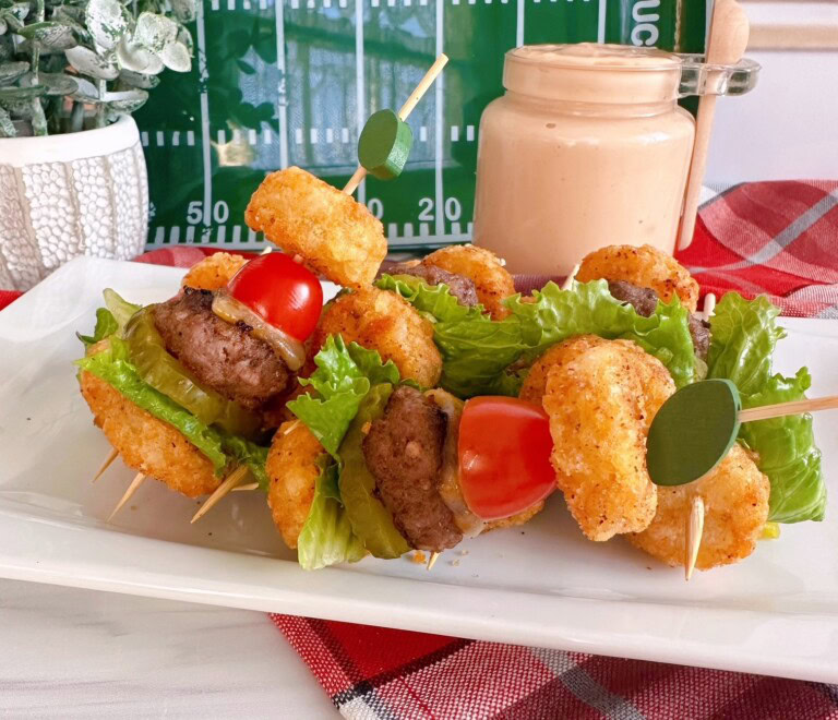 Tater Tot Mini Cheeseburger Bites on a white platter with secret sauce in a jar in the background.