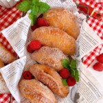 Fried raspberry filled hand pies in a paper lined basket.