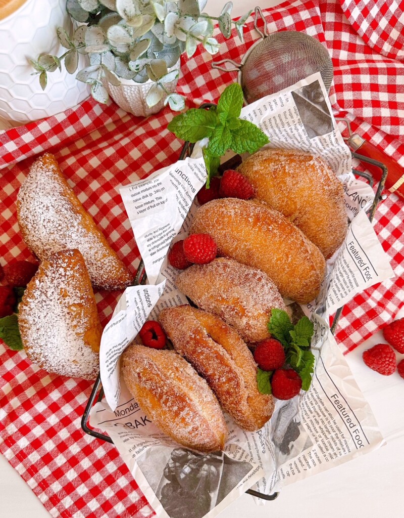Fried Biscuit Hand Pies in a basket with fresh raspberries and mint.
