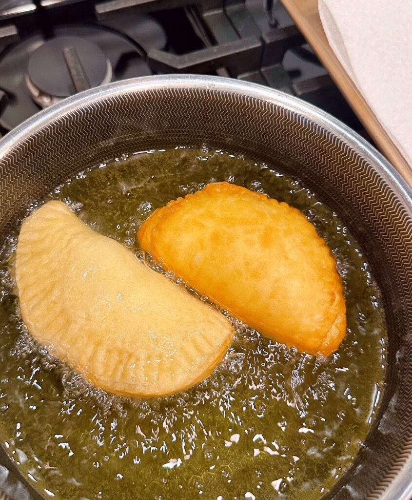 Frying Hand Pie in hot oil on stove top.