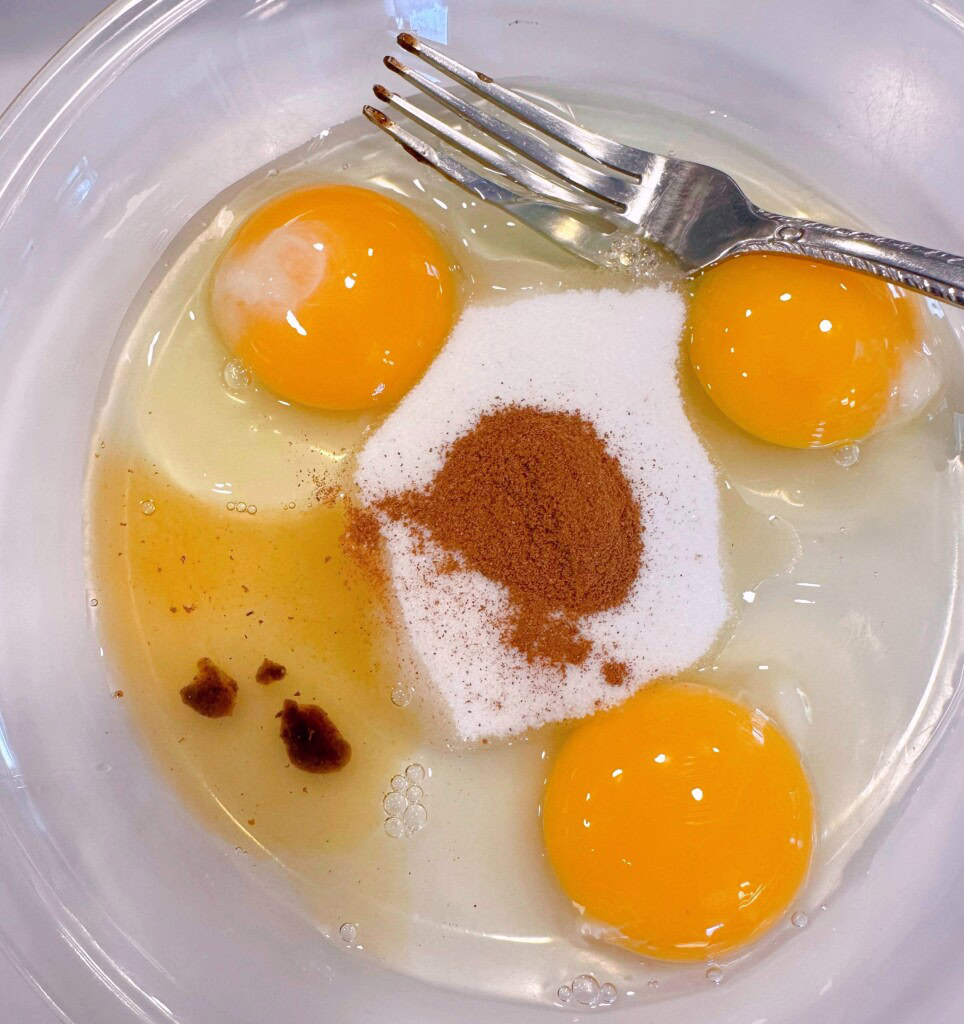 Combining eggs, sugar, cinnamon, and vanilla in a shallow dish.