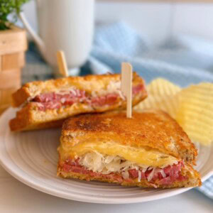 The BEST Rueben Corned Beef Sandwich on a plate with potato chips.