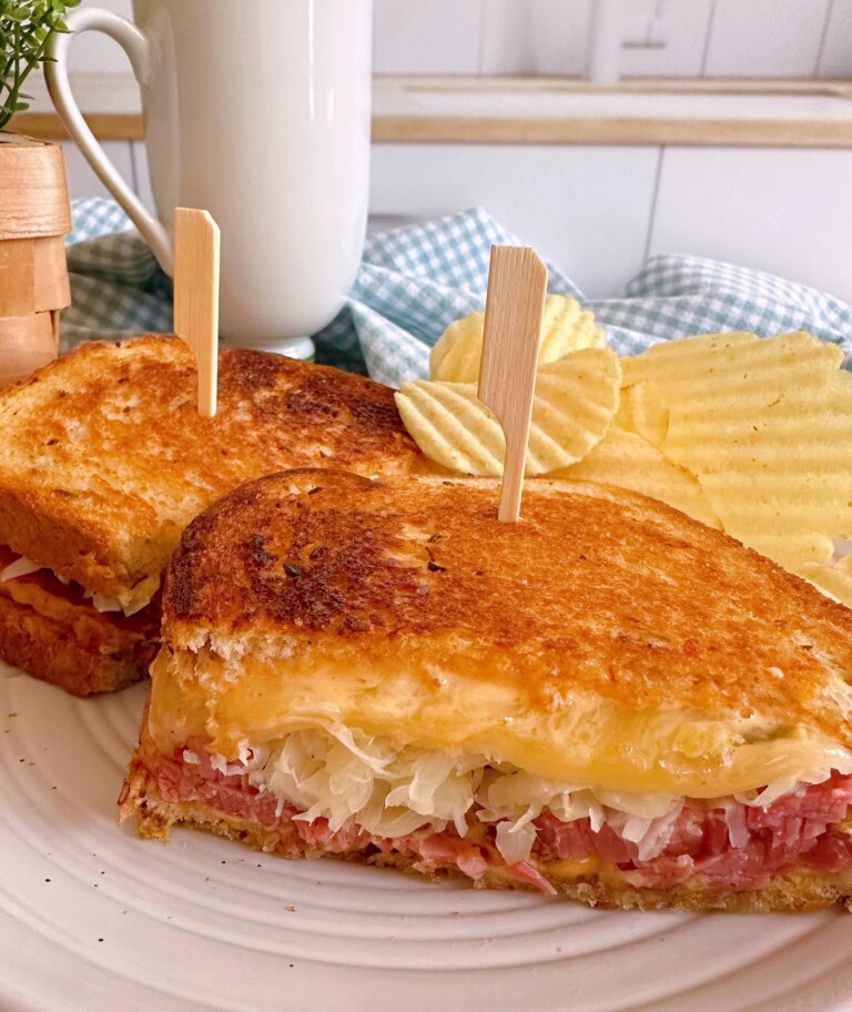 Traditional Instant Pot Corned Beef Sandwich sliced and on a plate with chips!
