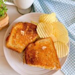 Rueben sandwich cut and served with potato chips.