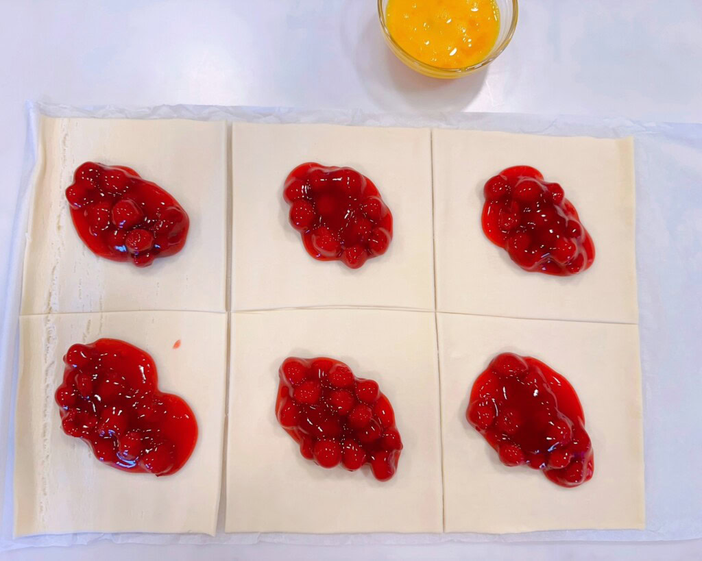 Cherry Pie filling scooped into the center of each puff pastry square.