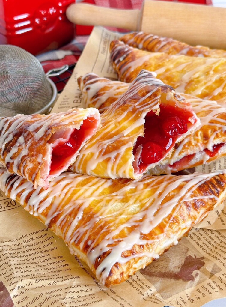 Easy Cherry Turnovers stacked with one broken open to reveal cherry pie filling.