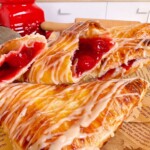 Cherry turnovers broken in half to reveal cherry pie filling.