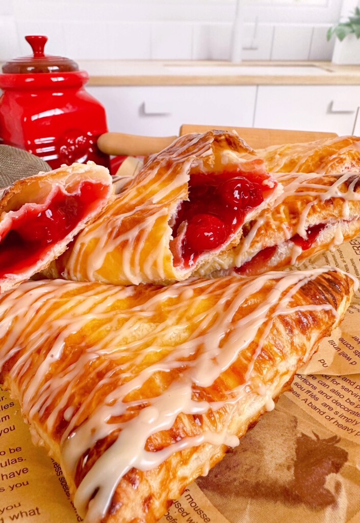 Cherry turnovers broken in half to reveal cherry pie filling.