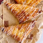 Turnovers with glaze drizzled over the top of each cherry turnover.