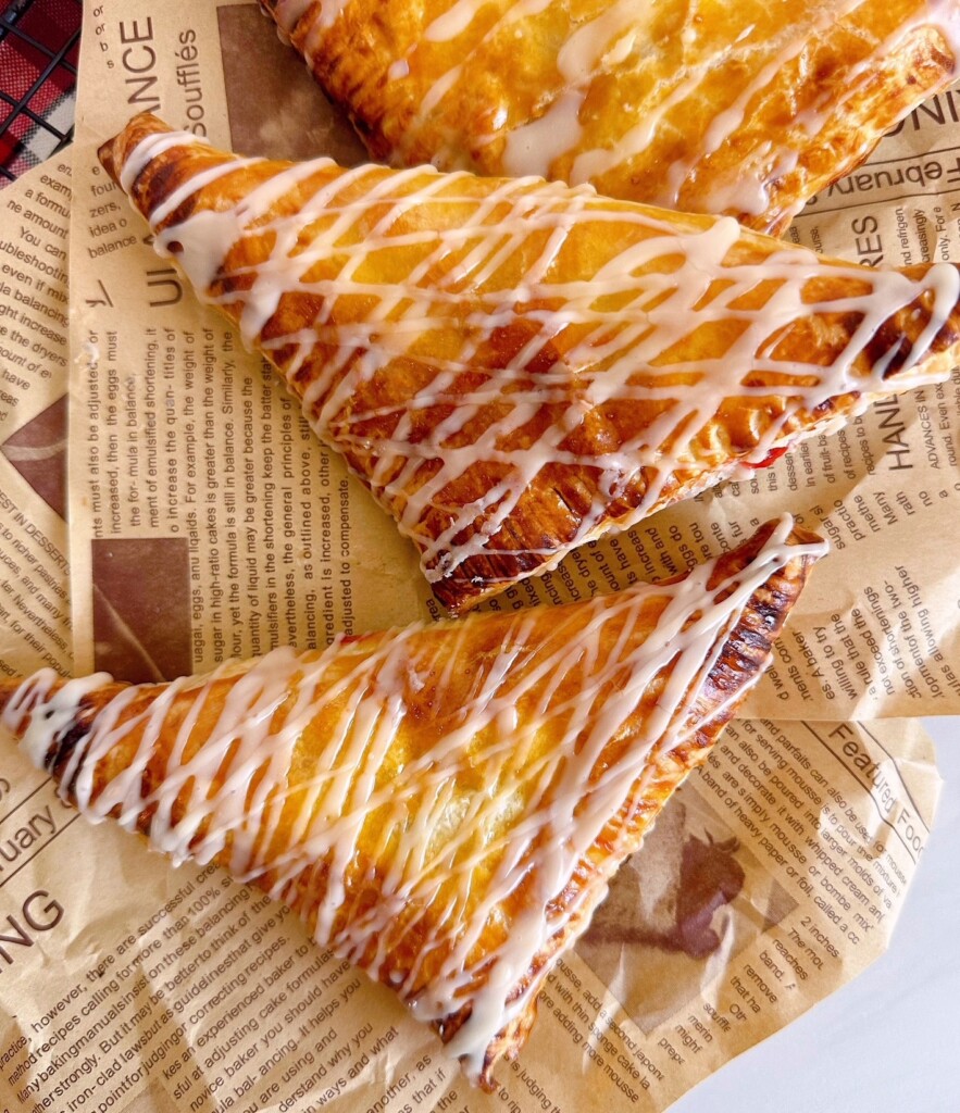 Turnovers with glaze drizzled over the top of each cherry turnover.
