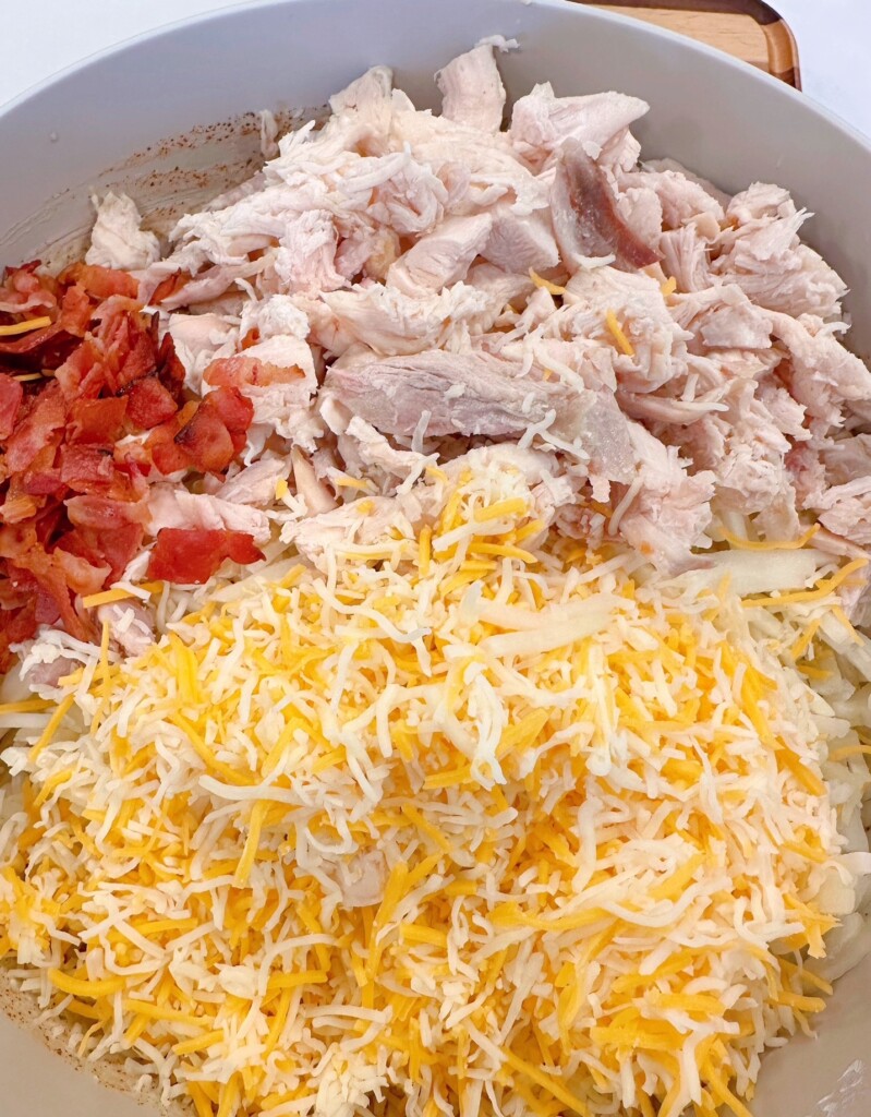 Adding chicken, bacon, and cheese into wet ingredients.