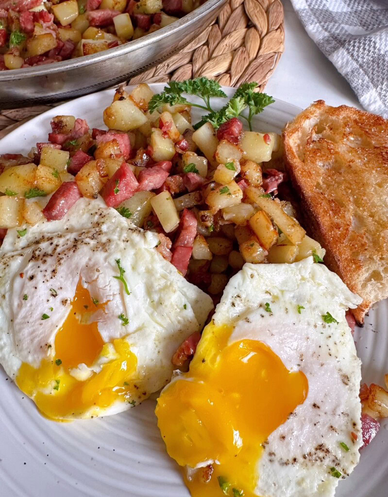 Eggs with corned beef hash with the yolk running down the hash.