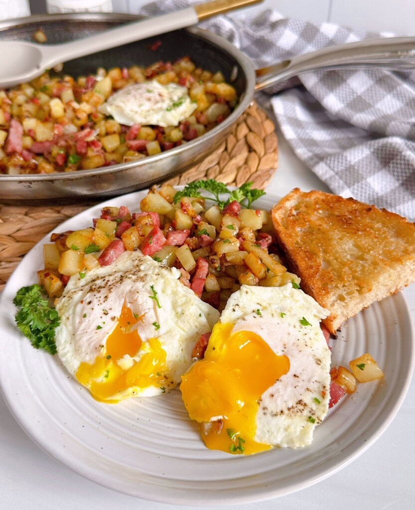 Serving of hash with runny eggs and toast.