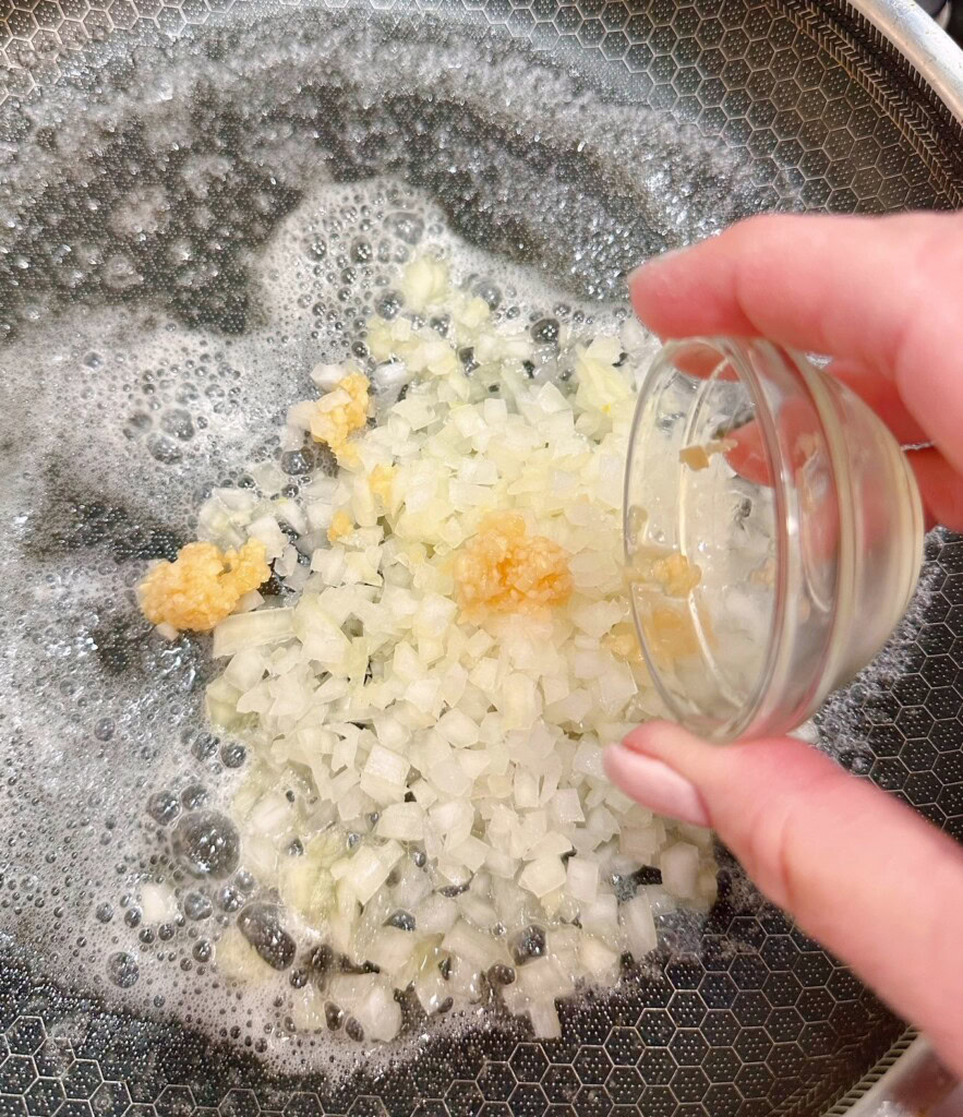 Skillet with onion, garlic, and melted butter.