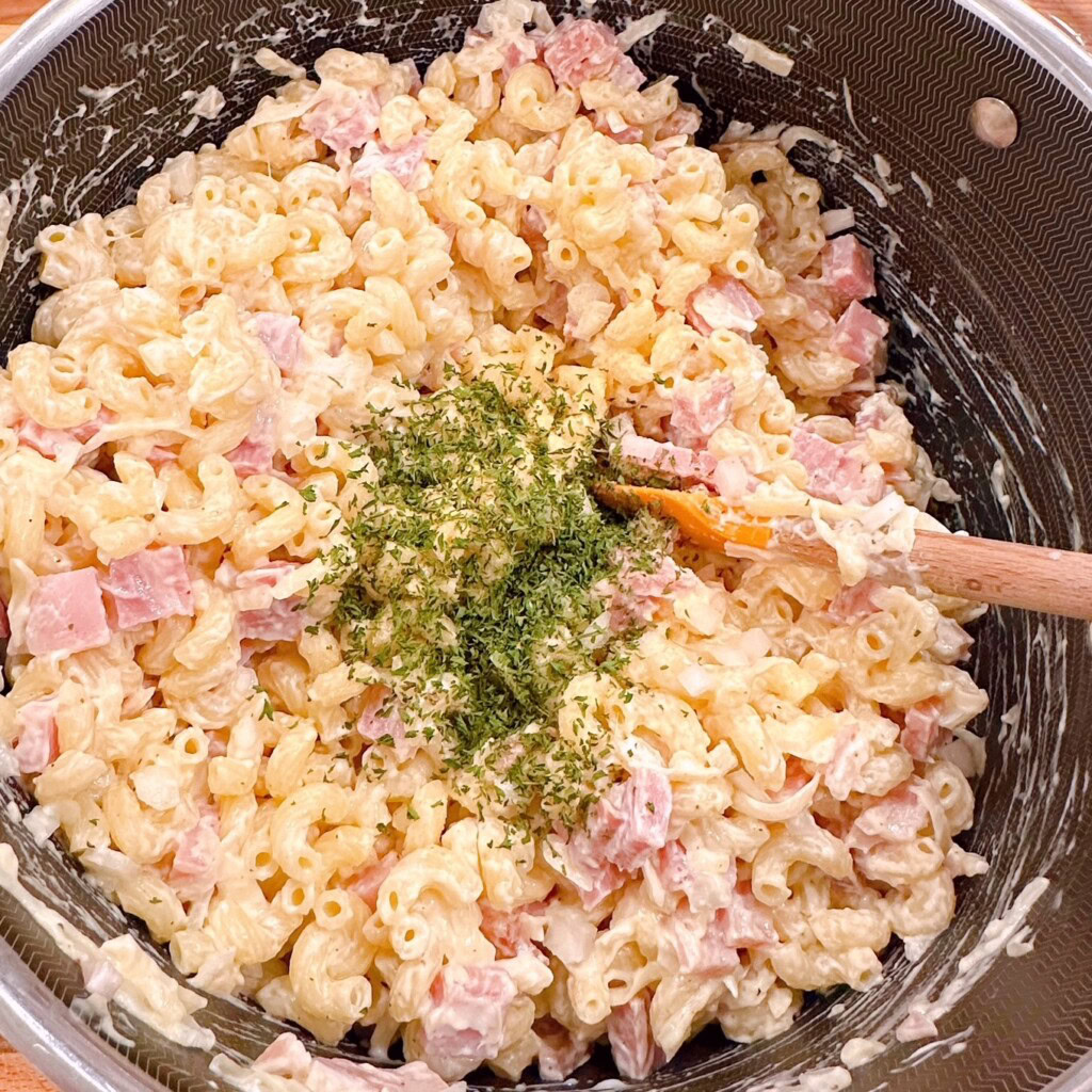 Adding Parsley to pasta mixture.