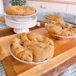 Mini Chocolate Chip S'mores Pies on a small cutting board cooling.