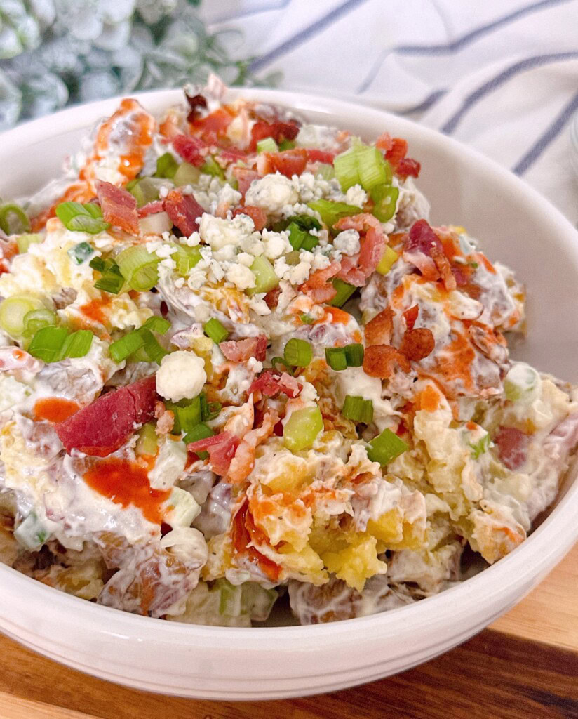 Smashed Buffalo Potato Salad in a white serving bowl.