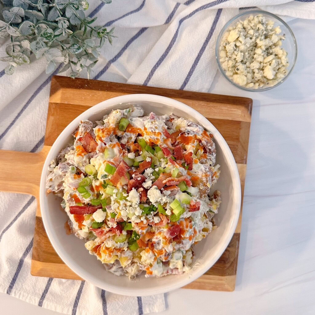 Smashed potato salad with serving of blue cheese on the side.