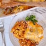 Easy Ground Beef Casserole in a casserole dish with a single serving on a dinner plate with a fork.