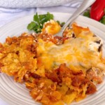 Taco casserole on a dinner plate with a fork in it.