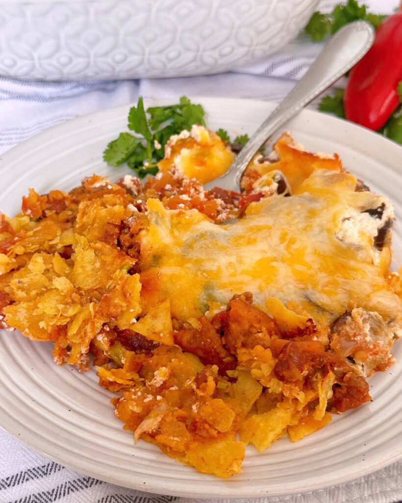 Taco casserole on a dinner plate with a fork in it.
